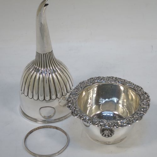 A very handsome Antique Georgian Sterling Silver wine decanting funnel, having a round body with hand-chased half-fluted decoration, and a pull out strainer with a shell clip and a shell and scroll border. Made by William Eley and William Fearn of London in 1826. The dimensions of this fine hand-made silver wine decanting funnel are height 15 cms (6 inches), diameter of cup 9.5 cms (3.75 inches), and it weighs approx. 198g (6.4 troy ounces).