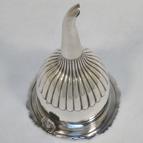 A very handsome Antique Georgian Sterling Silver wine decanting funnel, having a round body with hand-chased half-fluted decoration, and a pull out strainer with a shell clip and a shell and scroll border. Made by William Eley and William Fearn of London in 1826. The dimensions of this fine hand-made silver wine decanting funnel are height 15 cms (6 inches), diameter of cup 9.5 cms (3.75 inches), and it weighs approx. 198g (6.4 troy ounces).