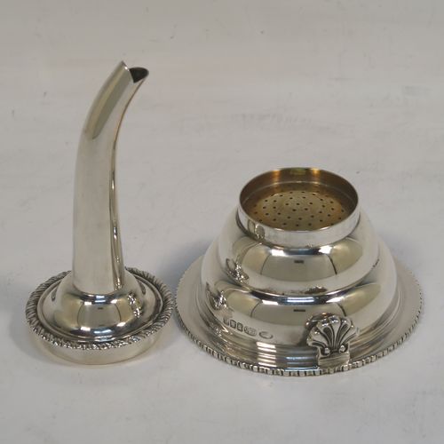 An elegant Scottish Sterling Silver wine decanting funnel, having a plain round body with a gold-gilt interior and applied gadroon borders, a cast shell side clip, and removable funnel. This handsome silver wine decanting funnel was made by Goodwins of Edinburgh in 2001. The dimensions of this fine hand-made silver wine decanting funnel are height 13 cms (5 inches), diameter of bowl 8 cms (3 inches), and it weighs approx. 127g (4 troy ounces).