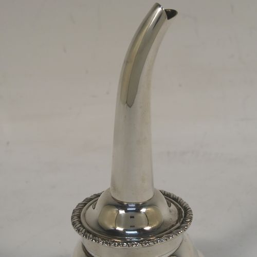 An elegant Scottish Sterling Silver wine decanting funnel, having a plain round body with a gold-gilt interior and applied gadroon borders, a cast shell side clip, and removable funnel. This handsome silver wine decanting funnel was made by Goodwins of Edinburgh in 2001. The dimensions of this fine hand-made silver wine decanting funnel are height 13 cms (5 inches), diameter of bowl 8 cms (3 inches), and it weighs approx. 127g (4 troy ounces).