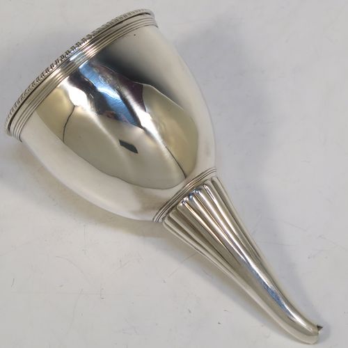 A very handsome Antique Georgian Sterling Silver wine decanting funnel, having a round body with hand-chased reeded and fluted decoration, and a pull-out strainer with an applied gadroon border. This elegant antique silver wine decanting funnel was made by William Akken III of London in 1800. The dimensions of this fine hand-made antique silver wine decanting funnel are height 14 cms (5.5 inches), diameter of cup 3.5 cms (3 inches), and it weighs approx. 142g (4.6 troy ounces).