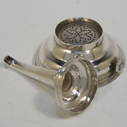 A very handsome Antique Georgian Sterling Silver wine decanting funnel, having a plain round body with an applied double feather-edged border and a cast shell style side clip, and original removable funnel. This elegant antique silver wine funnel was made in London in 1819. The dimensions of this fine hand-made antique silver wine decanting funnel are height 13 cms (5 inches), diameter of bowl 9.5 cms (3.75 inches), and it weighs approx. 102g (3.3 troy ounces).