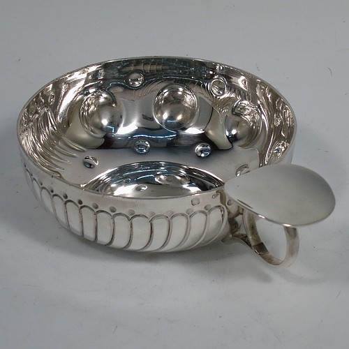 An Antique Victorian Silver French wine taster, having a round body, with hand-chased swirl-fluted and dimple decoration, a loop handle with plain thumb-piece, and sitting on a concave base with nine hand-chased beads running around the inside. Made in Paris, France ca. 1890, with a Minerva 1st Quality mark, indicating 950 standard silver. The dimensions of this fine hand-made antique silver wine taster or testavine are diameter 8 cms (3 inches), and height 3 cms (1.3 inch), and it weighs approx. 100g (3.2 troy ounces).    