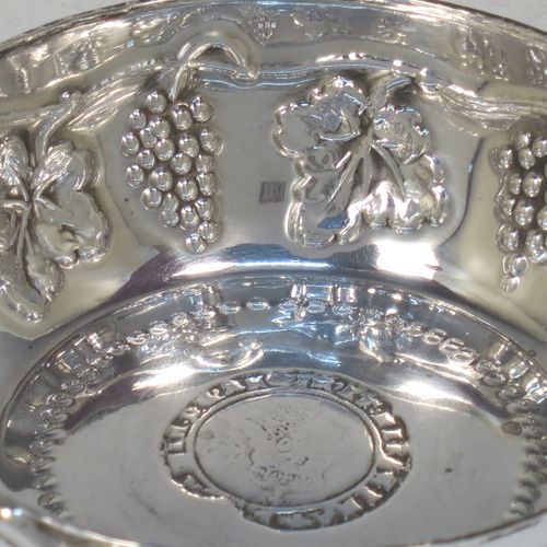 A large, heavy, and very handsome Sterling Silver testavine or wine taster, having a round body, with hand-chased grape-vine decoration, a cast snake head loop handle, and sitting on a flat base with bead-work decoration and inlet coin. Made by D. and J. Welby of London in 1925. The dimensions of this fine hand-made silver wine taster testavine are diameter 9.5 cms (3.75 inches), and height 3 cms (1.25 inch), and it weighs approx. 96g (3 troy ounces).   