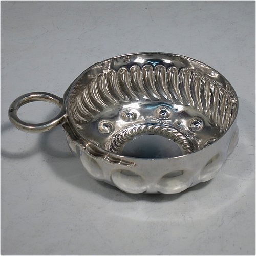 An Antique Victorian Silver French wine taster, having a round body, with hand-chased swirl-fluted decoration, a cast snake head loop handle, and sitting on a concave base with eleven hand-chased beads running around the inside. Made in Paris, France ca. 1890, with a Minerva 1st Quality mark, indicating 950 standard silver. The dimensions of this fine hand-made antique silver wine taster or testavine are diameter 8 cms (3 inches), and height 3 cms (1.3 inch), and it weighs approx. 90g (3 troy ounces).    