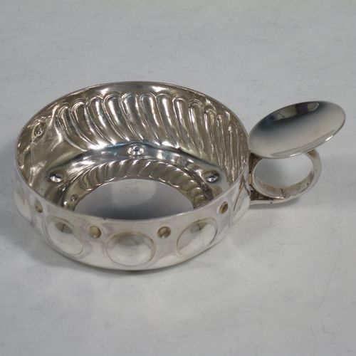 A pretty Antique Victorian Silver French testavine or wine taster, having a round body, with hand-chased bead and swirl-fluted decoration, a loop handle with thumb-piece, and sitting on a concave base. Made in Paris, France ca. 1890, with a Minerva 1st Quality mark, indicating 950 standard silver. The dimensions of this fine hand-made antique silver wine taster or testavine are diameter 7 cms (2.75 inches), and height 3 cms (1.3 inch), and it weighs approx. 72g (2.3 troy ounces).   
