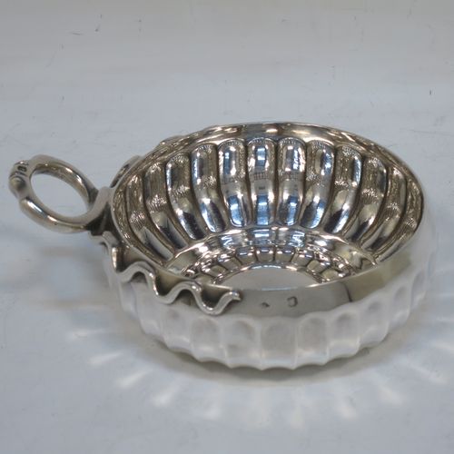 An Antique Victorian Silver French tasse de vin or wine taster, having a round body, with hand-chased fluted decoration, an applied cast snake head loop handle, and sitting on a concave base. Made in Paris, France ca. 1900, with a Minerva 1st Quality mark, indicating 950 standard silver. The dimensions of this fine hand-made antique silver wine taster or testavine are diameter 9 cms (3.5 inches), and height 4 cms (1.5 inch), and it weighs approx. 105g (3.4 troy ounces).  